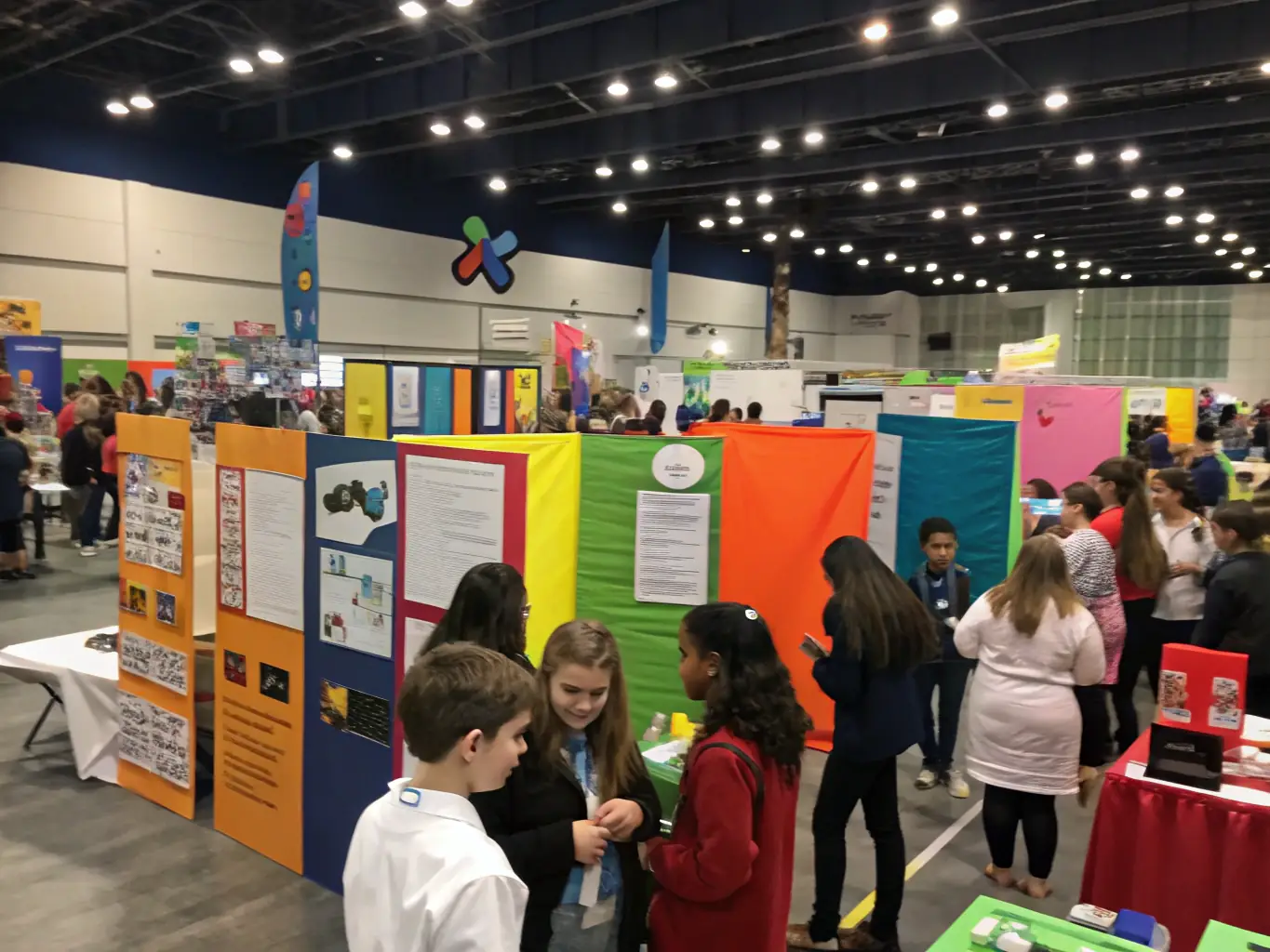 A dynamic image of a community science fair, featuring children and adults interacting with interactive science exhibits, highlighting MAKAZA's commitment to integrating science with art and community engagement.